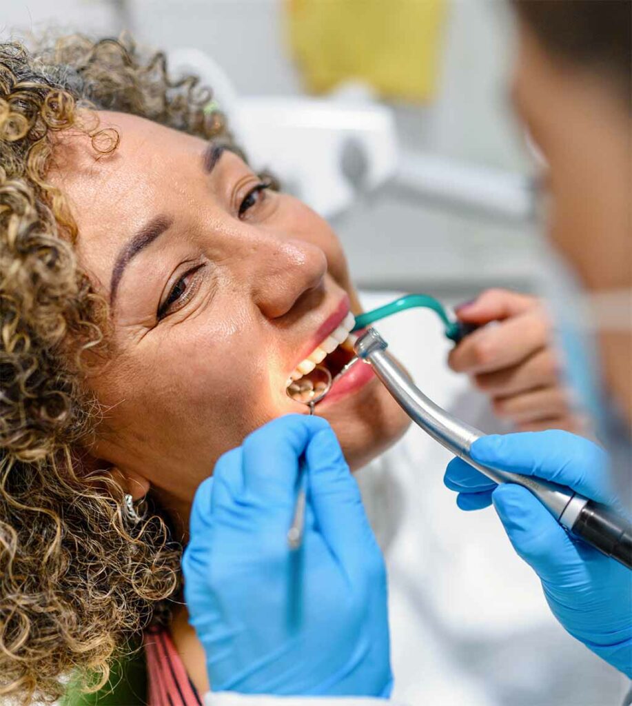 Woman undergoing periodontal treatment at Fay Periodontics, receiving expert care in a dental chair from a skilled periodontist.